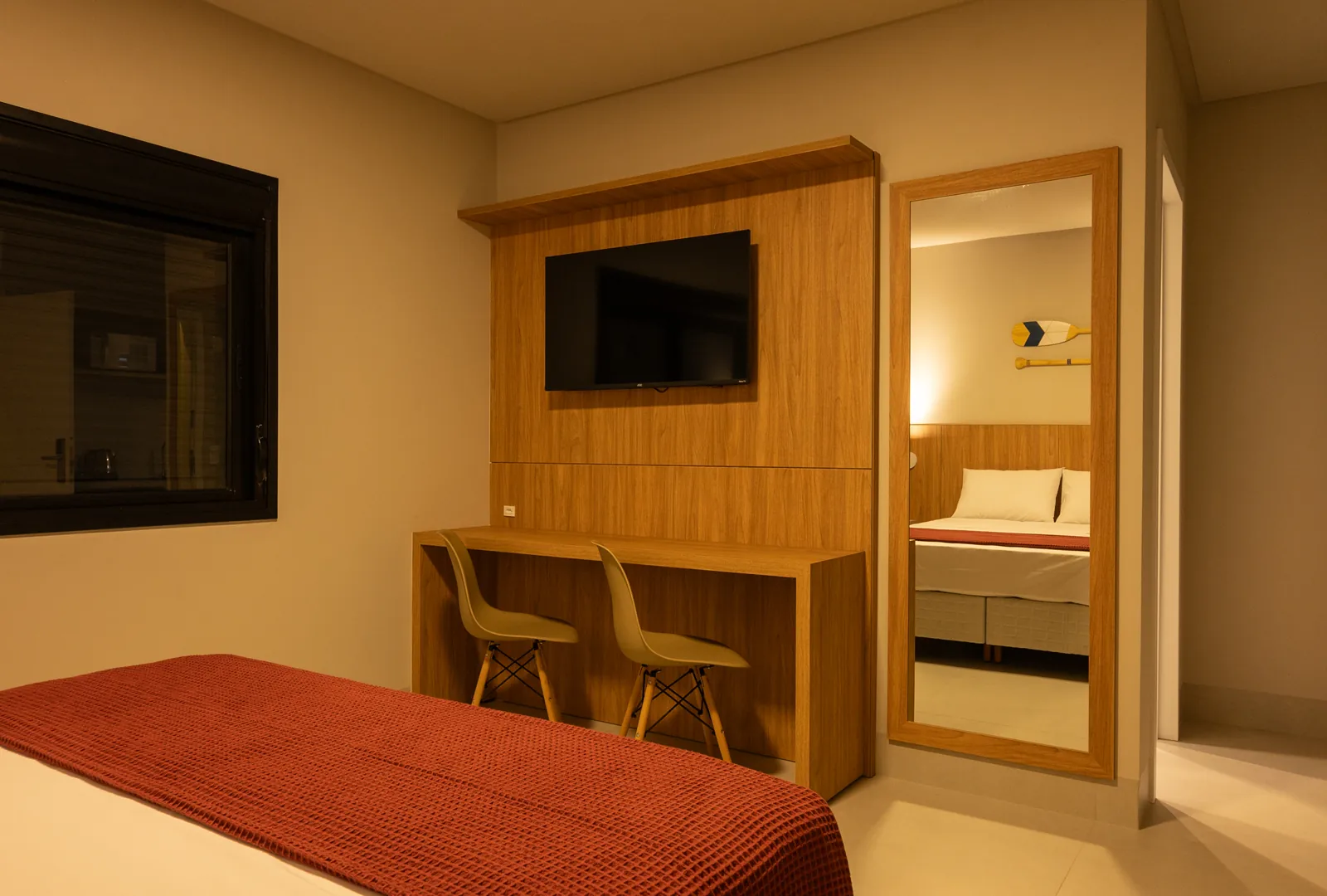 Quarto da Pousada Caminho do Bosque com TV a cabo, mesa de trabalho e decoração acolhedora, perfeito para relaxar após um dia de atividades.