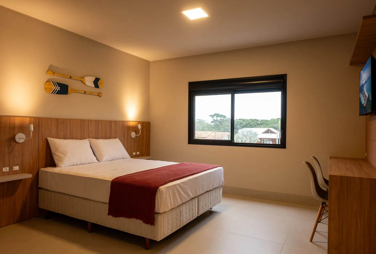 Quarto principal da unidade  com cama queen size e decoração aconchegante, perfeito para relaxar após um dia em Bombinhas.