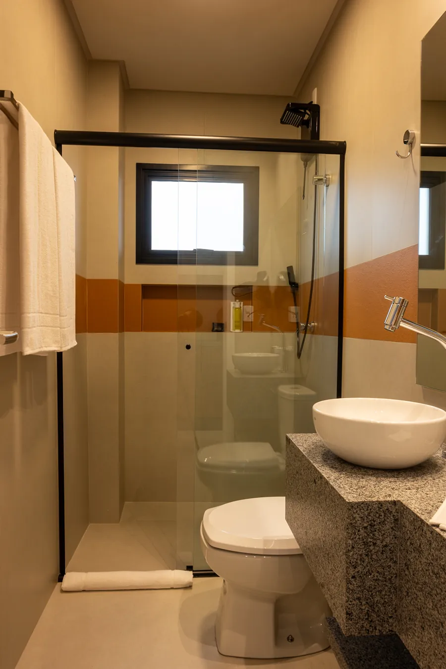 Banheiro completo e adaptado na Pousada Caminho do Bosque, com barras de apoio, espelho ajustável e design funcional para maior conforto.