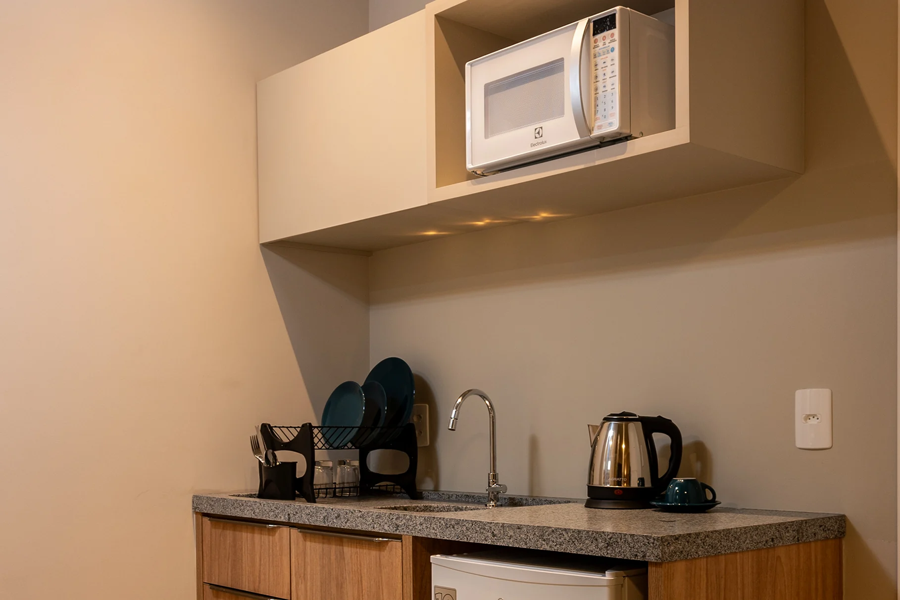 Cozinha equipada da Unidade , com utensílios modernos, micro-ondas e bancada prática para refeições em família.