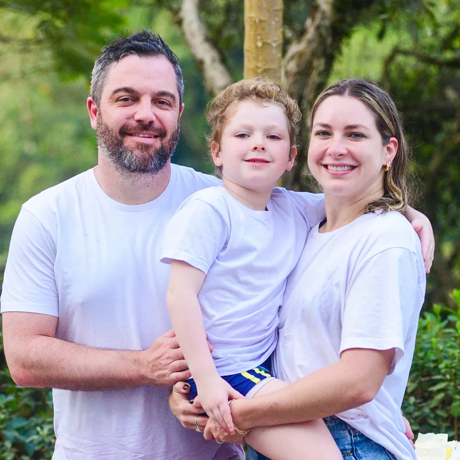 Luiz Felipe e sua família sorrindo juntos em um momento especial, destacando o ambiente acolhedor da Pousada Caminho do Bosque.